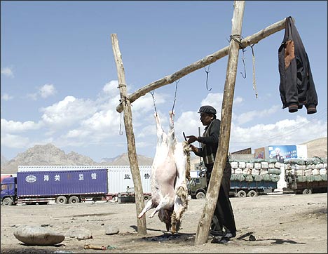 Chinese Irkeshtam. Mamatkali's helper carves a mutton