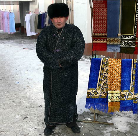 Торговец на рынке Ташкента в национальном узбекском халате - чапане