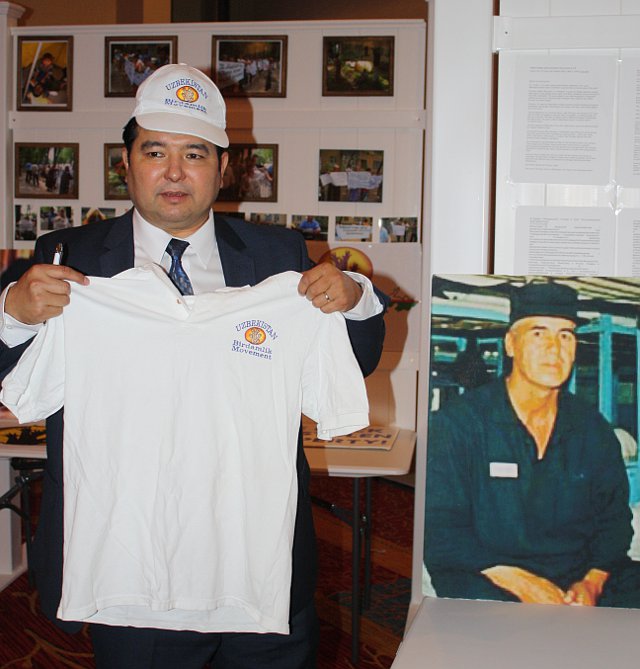 Bakhodir Choriyev with samples of campaign materials, including T-shirts and caps